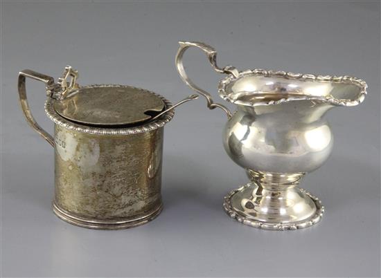An Edwardian silver baluster cream jug, Chester 1909 and a silver drum shaped mustard pot.
